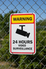 Warning sign for 24 hours video surveillance on a chain-link fence