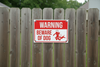 beware of dog sign attached to wooden fence