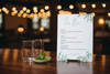 Bar menu on a wooden table with blurred lights in the background