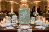 Table setup with gift boxes and a 'cards & gifts' sign in a festive indoor setting.