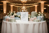 Table with gift boxes and a sign reading 'cards & gifts' in a decorated indoor setting.
